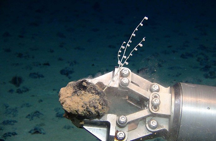deep sea mining machine holding a rock 
